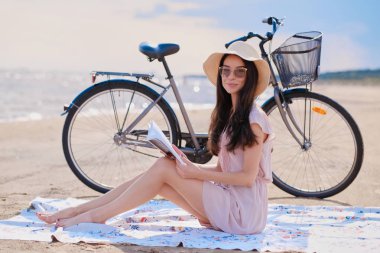 Deniz kenarında bisikletiyle güzel esmer portresi