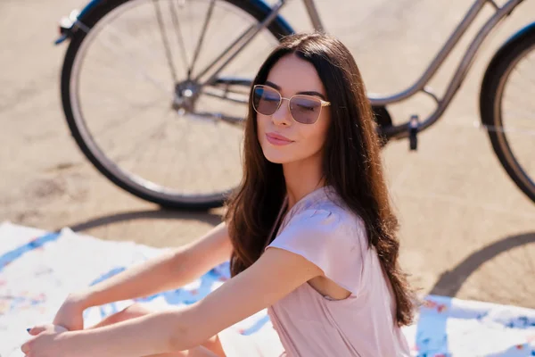 Retrato de bela morena com sua bicicleta à beira-mar — Fotografia de Stock