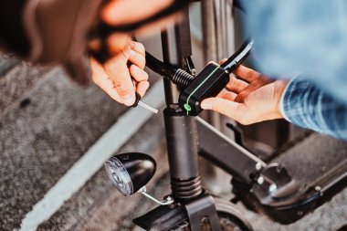 Adam üzerine elektro scooter ve ut zincir dolap park ediyor