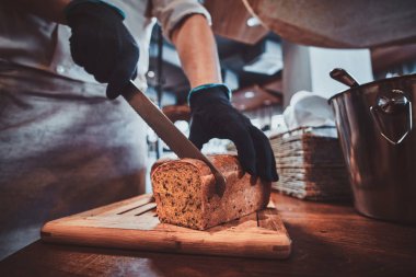 Mutfak işçisi öğle yemeği için ekmek dilimleme