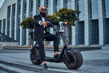 Adam yeni elektrikli bisikletine biniyor.