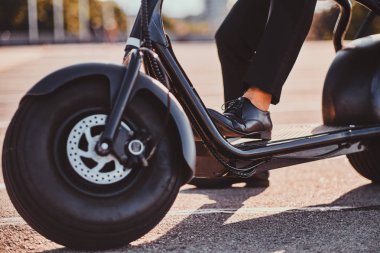 Adam yeni elektro scooter'ını kullanıyor.