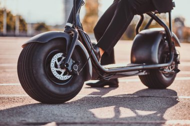 Adam yeni elektro scooter'ını kullanıyor.