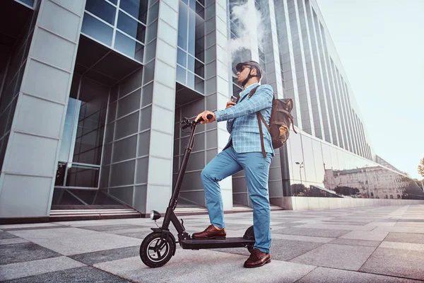 Elegante hombre con electro scooter está fumando vapor —  Fotos de Stock