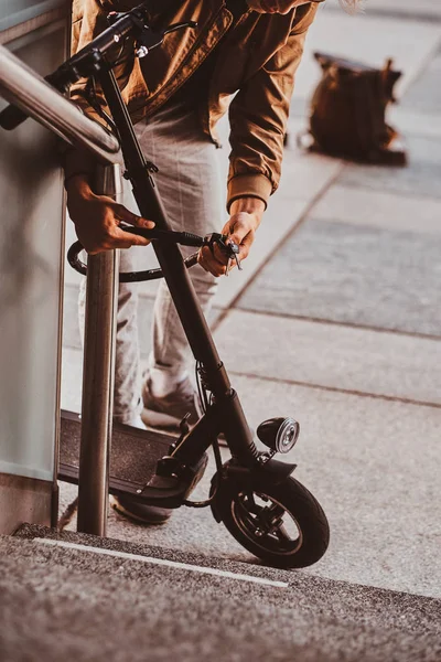 Man is het parkeren van zijn Electro scooter en UT Chain Locker op het — Stockfoto