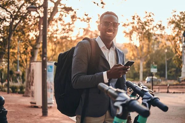 El hombre está pagando por electro scooter usando su teléfono móvil —  Fotos de Stock