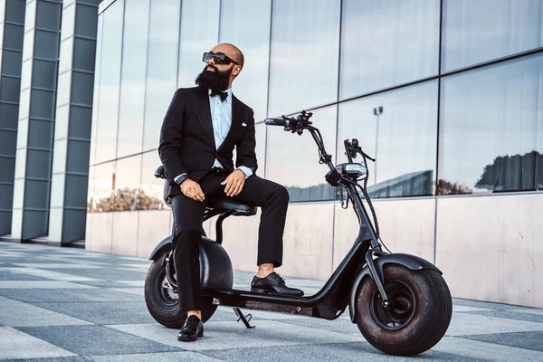 Modern adam yeni elektro scooter'ının üzerinde oturuyor.