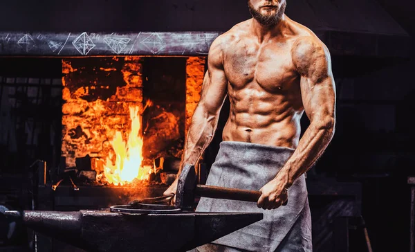 Güçlü demirci atölyesinde fotoğrafçı için poz