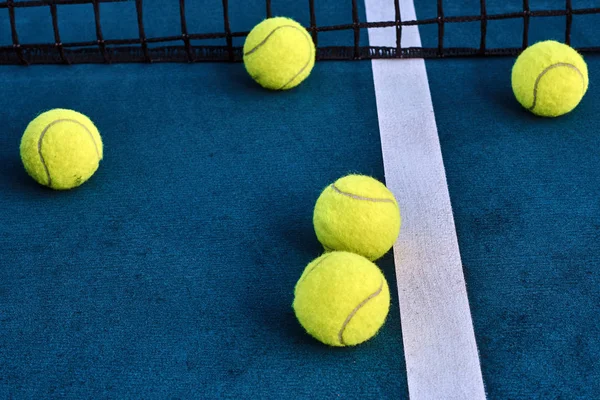 Tennisballer under nett ved banen – stockfoto