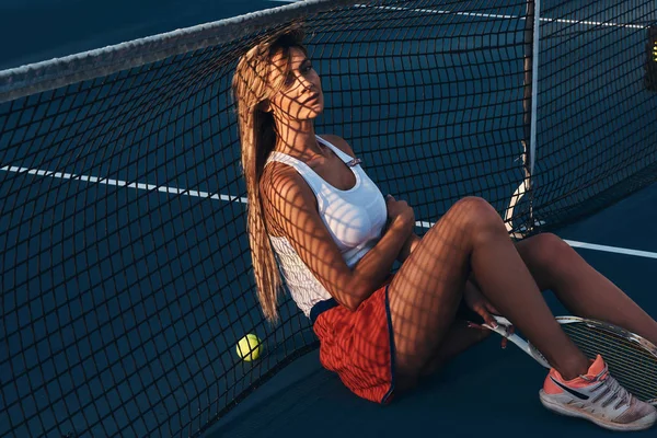 Όμορφη γυναίκα αναπαύεται στο γήπεδο τένις — Φωτογραφία Αρχείου