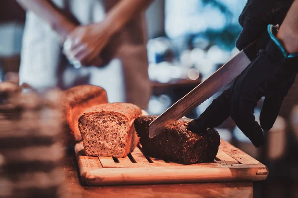 Mutfak işçisi öğle yemeği için ekmek dilimleme