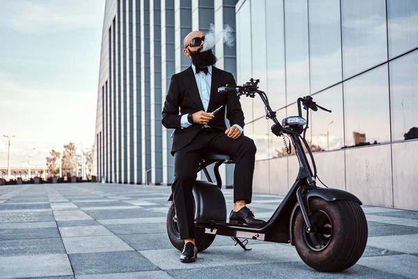 Eleganter Geschäftsmann raucht auf Elektro-Fahrrad — Stockfoto