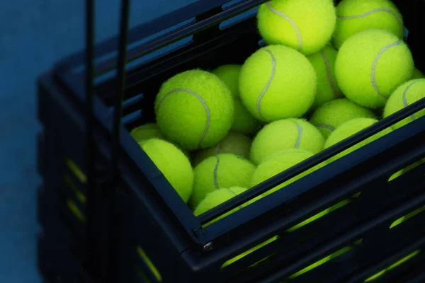 Caja negra con pelotas de tenis en el suelo — Foto de Stock