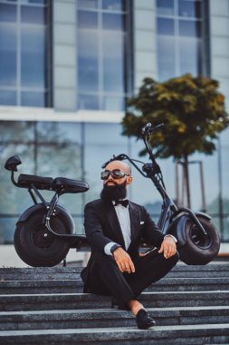 Adam modern elektro bisikletinin yanında poz ver.