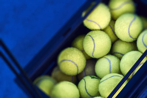 Caja negra con pelotas de tenis en el suelo — Foto de Stock