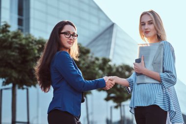 Ofis dışında iki genç kooperatif işçilerin el sıkışma
