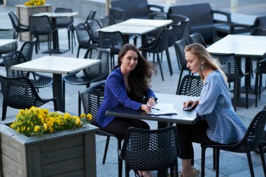 İki kooperatif çalışanı evrak işleri ile kafede oturuyor