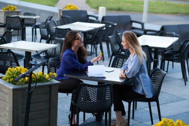 İki kooperatif çalışanı evrak işleri ile kafede oturuyor