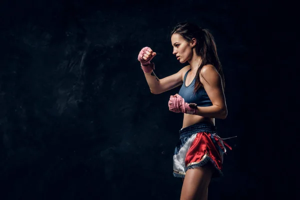 Retrato de una bonita boxeadora en un estudio fotográfico oscuro —  Fotos de Stock