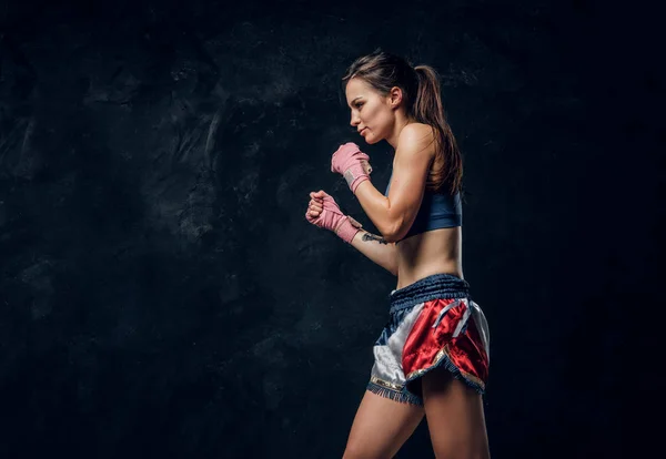 Retrato de una bonita boxeadora en un estudio fotográfico oscuro —  Fotos de Stock