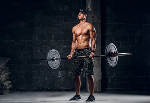 Man is doing exercises with heavy barbell — Stock Photo, Image