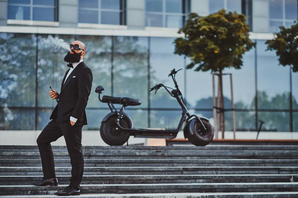 El hombre está posando cerca de su moderna bicicleta eléctrica —  Fotos de Stock