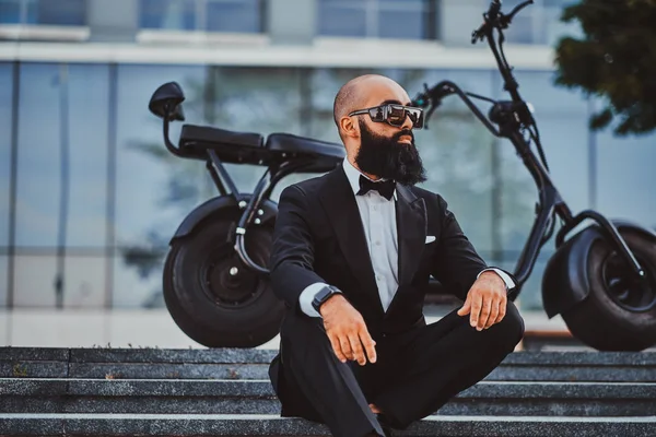 Adam modern elektro bisikletinin yanında poz ver.