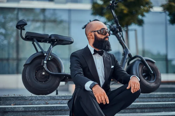 Adam modern elektro bisikletinin yanında poz ver.