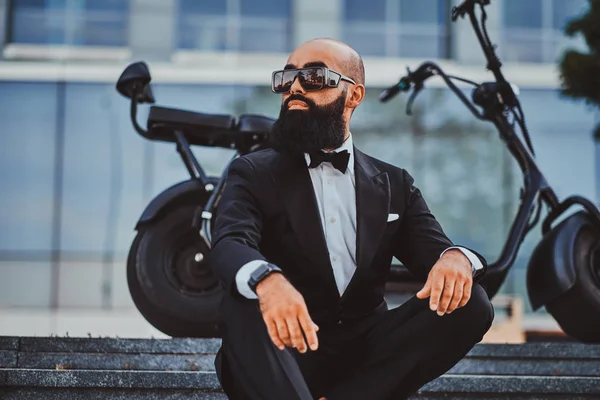 Adam modern elektro bisikletinin yanında poz ver.