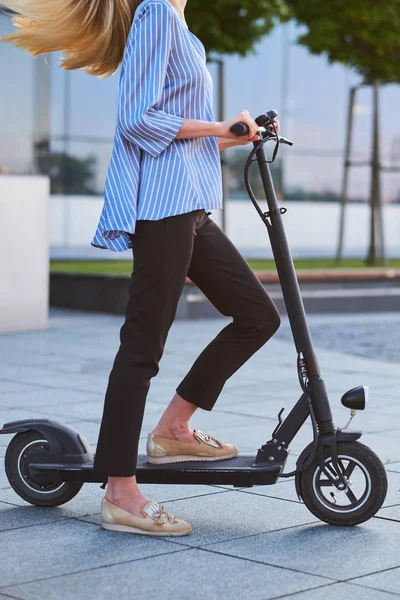 Jovem mulher está gostando de andar em sua nova scooter — Fotografia de Stock