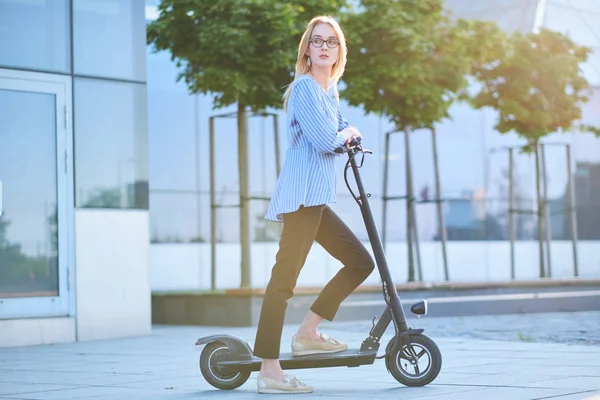 Mujer joven está disfrutando de montar en su nuevo scooter — Foto de Stock