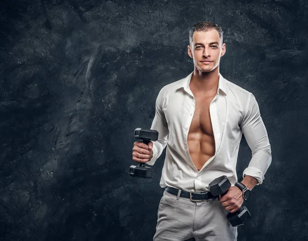 Привлекательный мужчина в белой рубашке в темной фотостудии — стоковое фото
