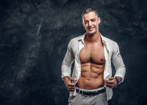 Homem atraente em camisa branca no estúdio de fotos escuras — Fotografia de Stock