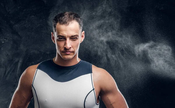 Koyu renk fotoğraf stüdyosunda dalış kıyafeti giymiş çekici adam