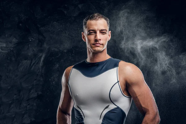 Attractive man in wetsuit in dark photo studio — Stock Photo, Image