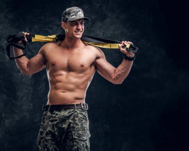 Koyu arka plan üzerinde gömleksiz kaslı adam portresi