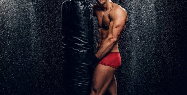 Hombre musculoso caliente con torso desnudo y saco de boxeo —  Fotos de Stock