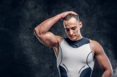 Koyu renk fotoğraf stüdyosunda dalış kıyafeti giymiş çekici adam