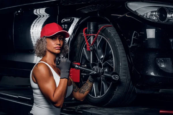 Женщина чинит шины для автомобилей в автосервисе — стоковое фото