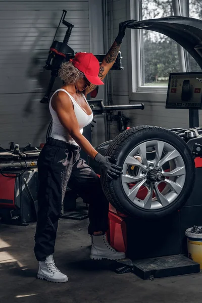 Vrouw is de vaststelling van een deel van gebroken auto — Stockfoto