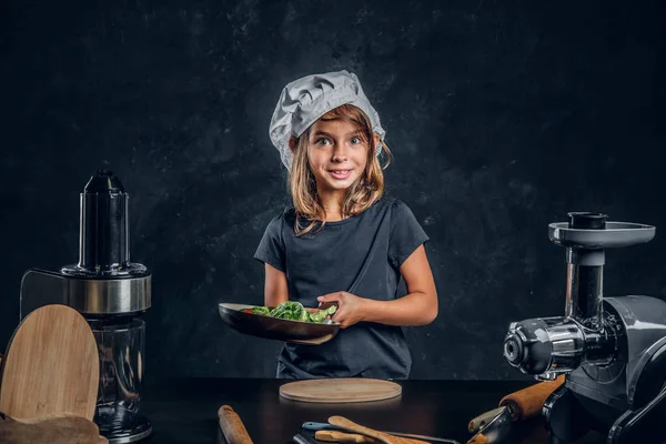 Küçük kız yemek pişirmek için sebze tamir ediyor — Stok fotoğraf