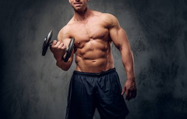 Güçlü erkek karanlık arka plan üzerinde halter ile egzersiz yapıyor