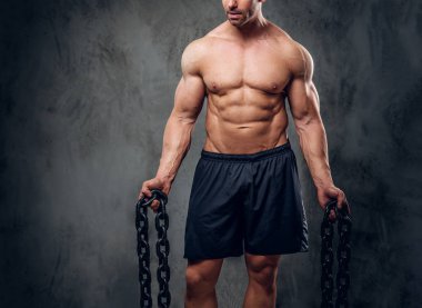 Güçlü vücut geliştirmeci karanlık arka planda poz