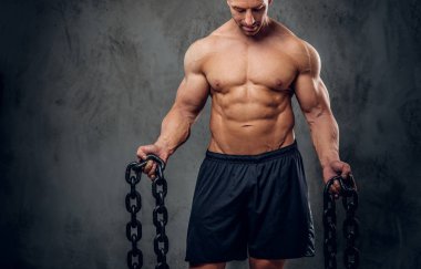 Güçlü vücut geliştirmeci karanlık arka planda poz