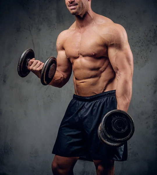 Sterke man doet oefeningen met barbells op de donkere achtergrond — Stockfoto