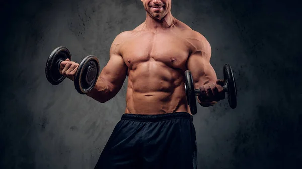 Sterke man doet oefeningen met barbells op de donkere achtergrond — Stockfoto