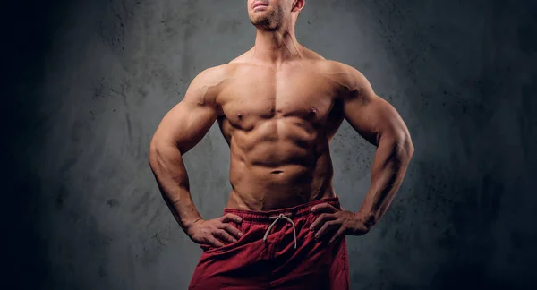 Mächtiger Bodybuilder posiert vor dunklem Hintergrund — Stockfoto