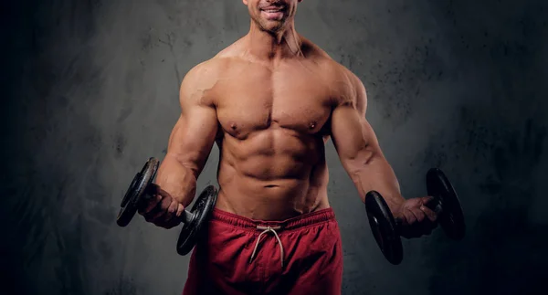 Sterke man doet oefeningen met barbells op de donkere achtergrond — Stockfoto