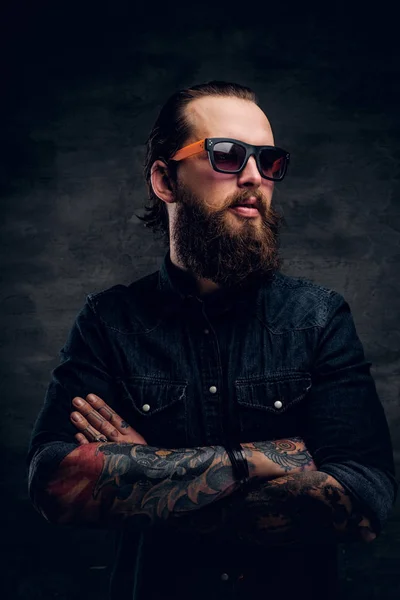 Hombre barbudo en gafas de sol está posando para el fotógrafo en el estudio de fotografía oscura . —  Fotos de Stock