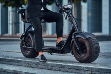 Adam yeni elektro scooter'ını kullanıyor.